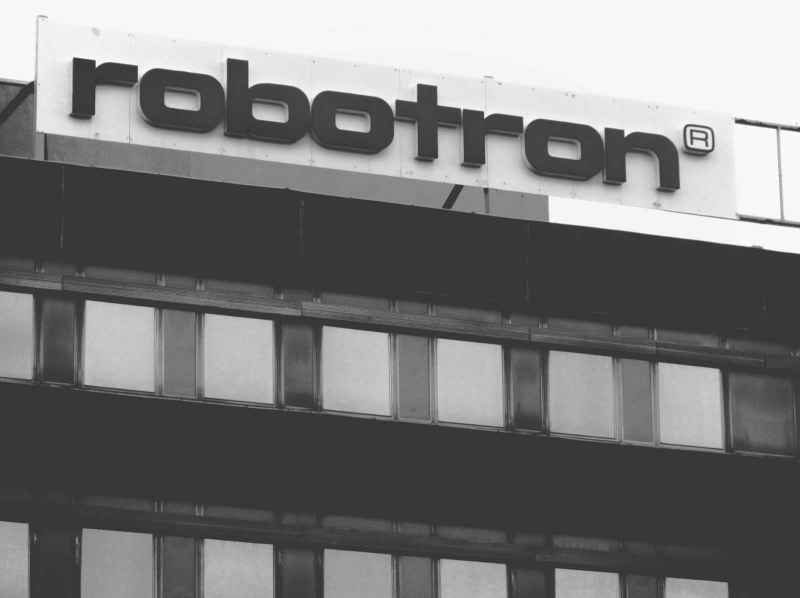 Historisches Schwarz-weiß-Bild eines Gebäudes in der ehemaligen DDR, darauf der Schriftzug „robotron“