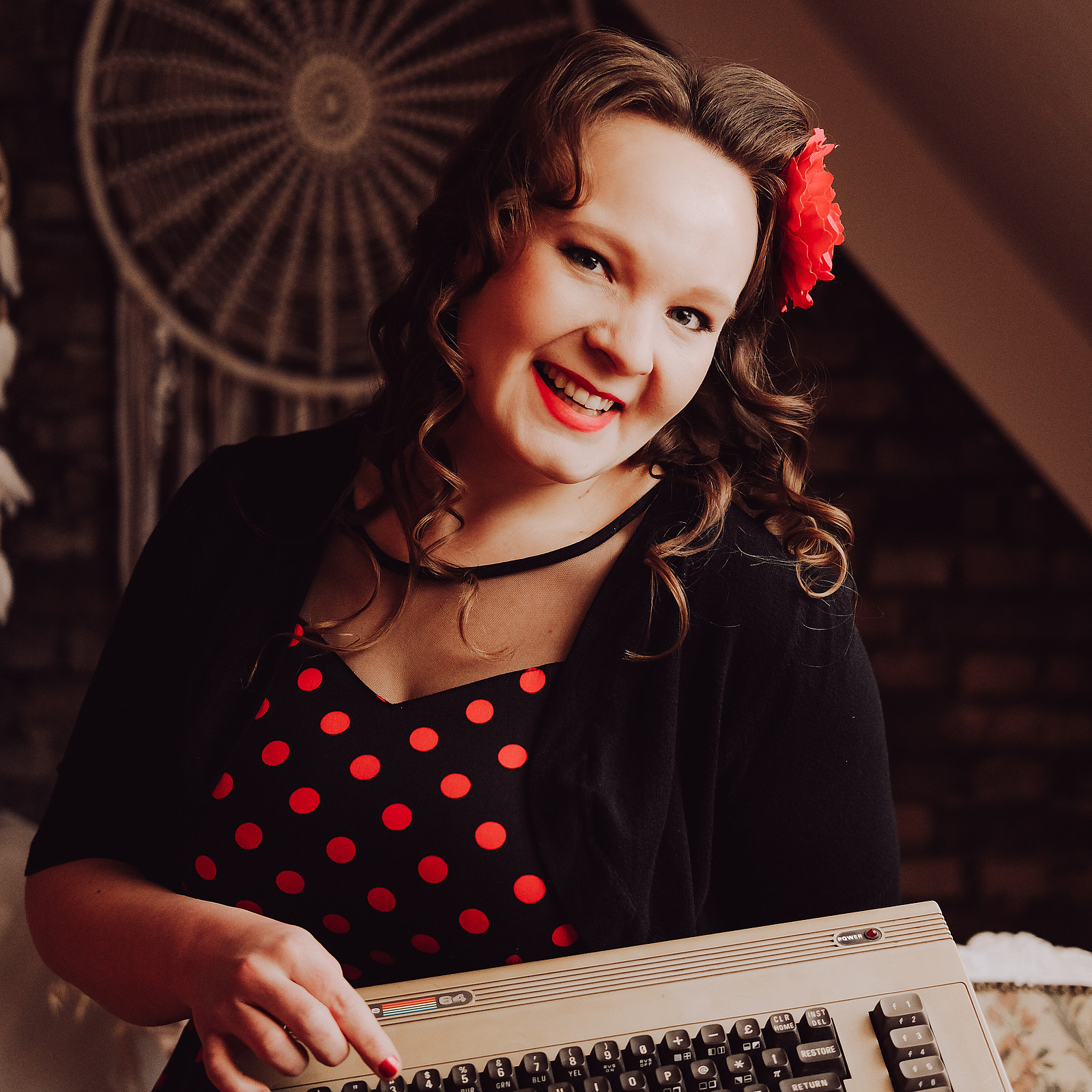 Porträt von Lea Schönberger, auf dem sie ein Kleid mit Polka-Dots sowie eine große Blume im Haar trägt