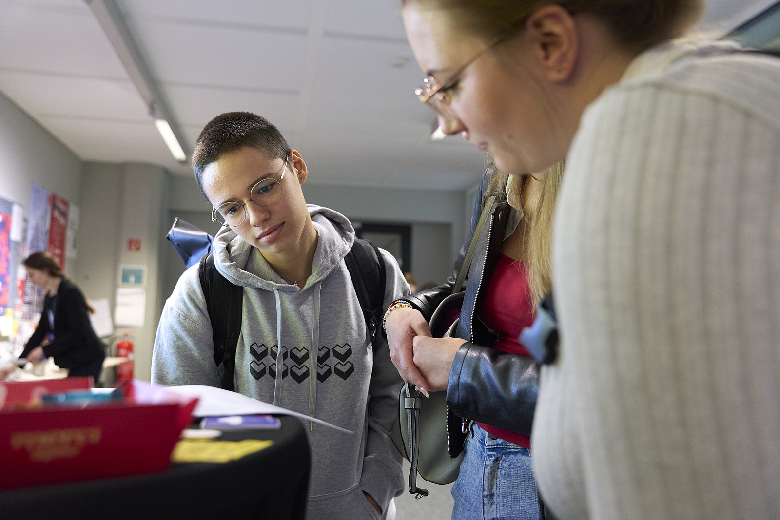 Zwei Teilnehmende des Festivals 2024 betrachten Publikationen am GI-Stand.