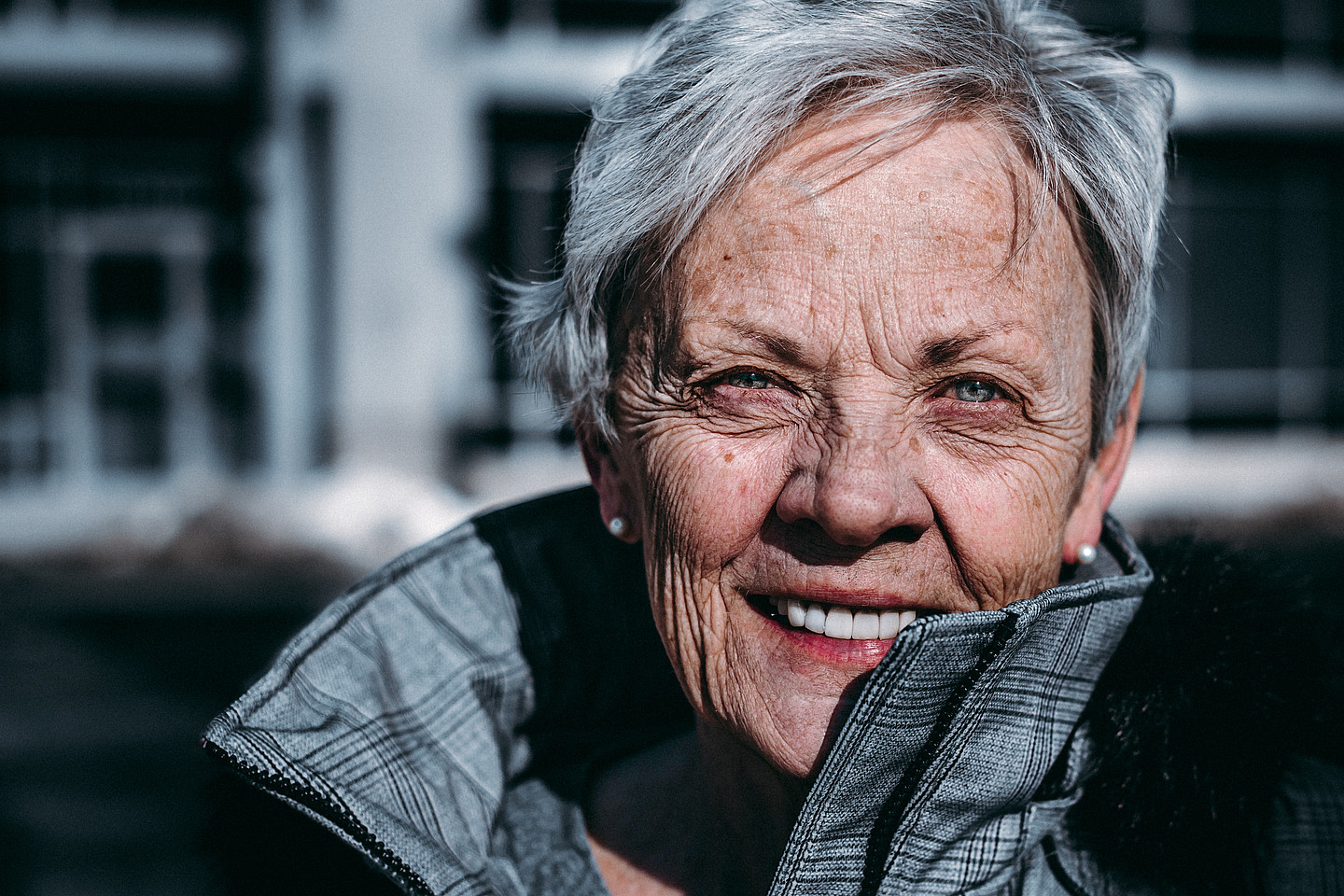 Eine ältere Dame lächelt in die Kamera